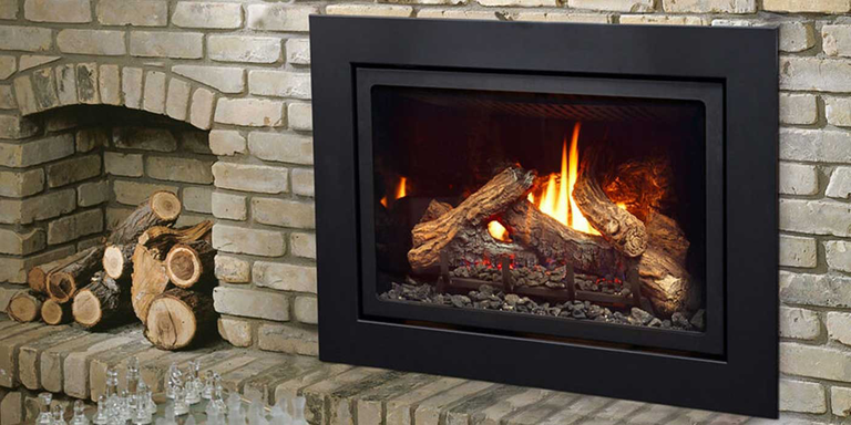 A classic wood burning stove insert with a stack of seasoned firewood 