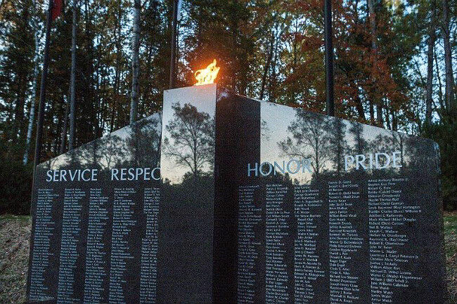 Close-up of the eternal burning flame in a gray granite veteran memorial