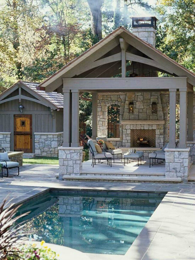 Covered outdoor living room with masonry fireplace adjacent to swimming pool