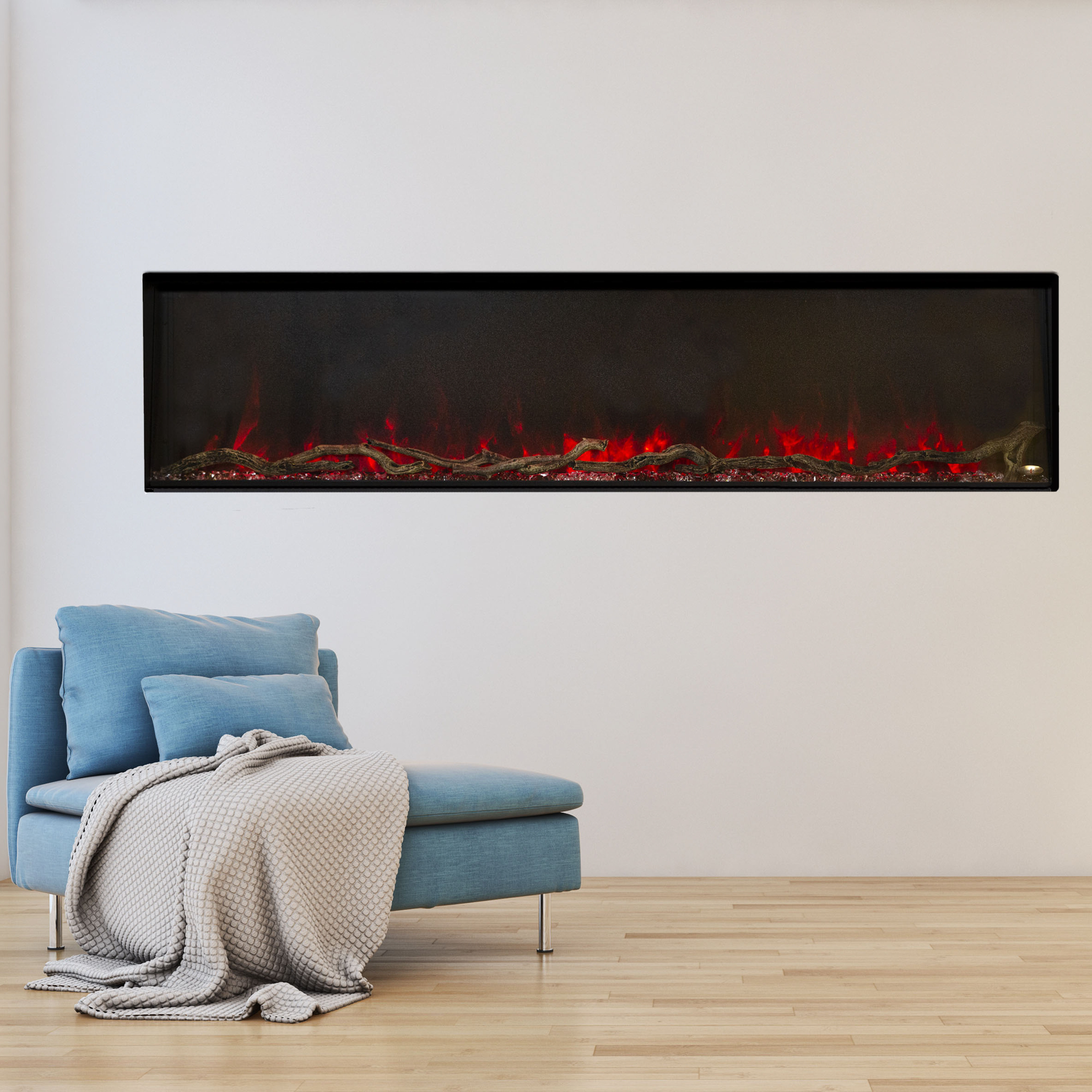 The Modern Flames Landscape Pro Slim electric fireplace installed next to a blue accent chair on a white wall.