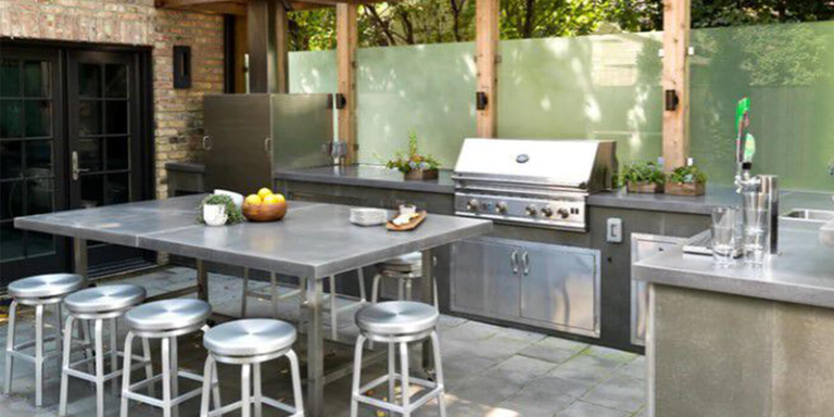 An outdoor kitchen island with concrete countertops