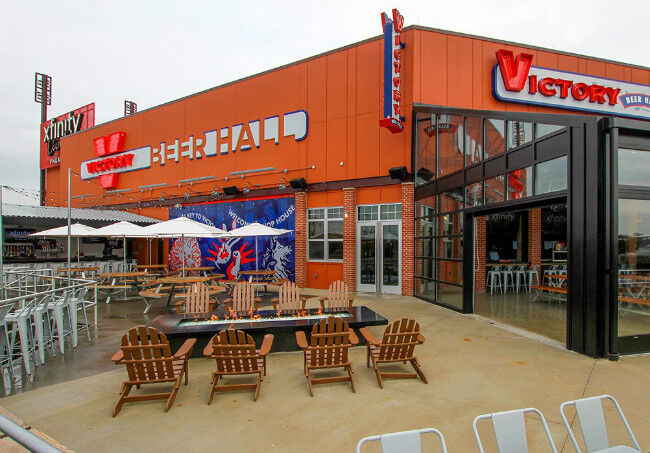 Adirondack chairs around a black fire table on the patio of the Victory Beer Hall