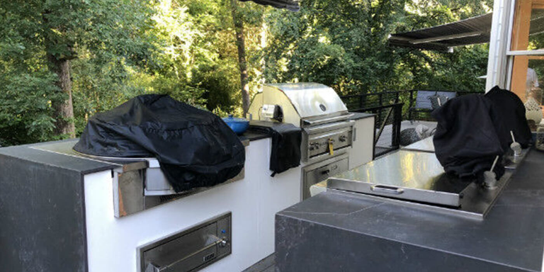 Gray and white outdoor kitchen island with drop-in cooktop and grill