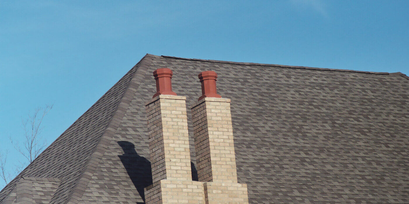 A traditional masonry chimney with two clay chimney pots on top