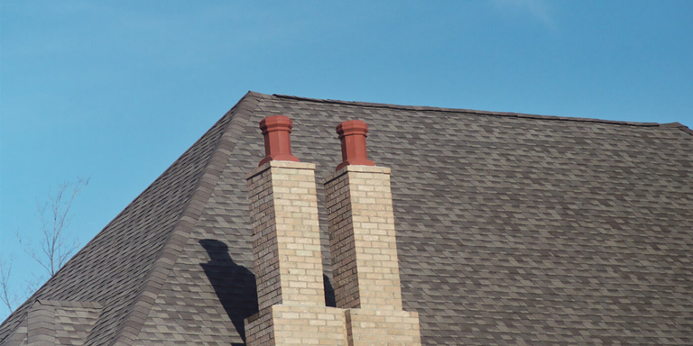 A traditional masonry chimney with two clay chimney pots on top