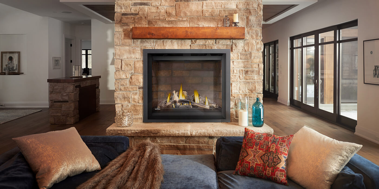 A rustic living space with a large traditional gas fireplace and decorative gas logs
