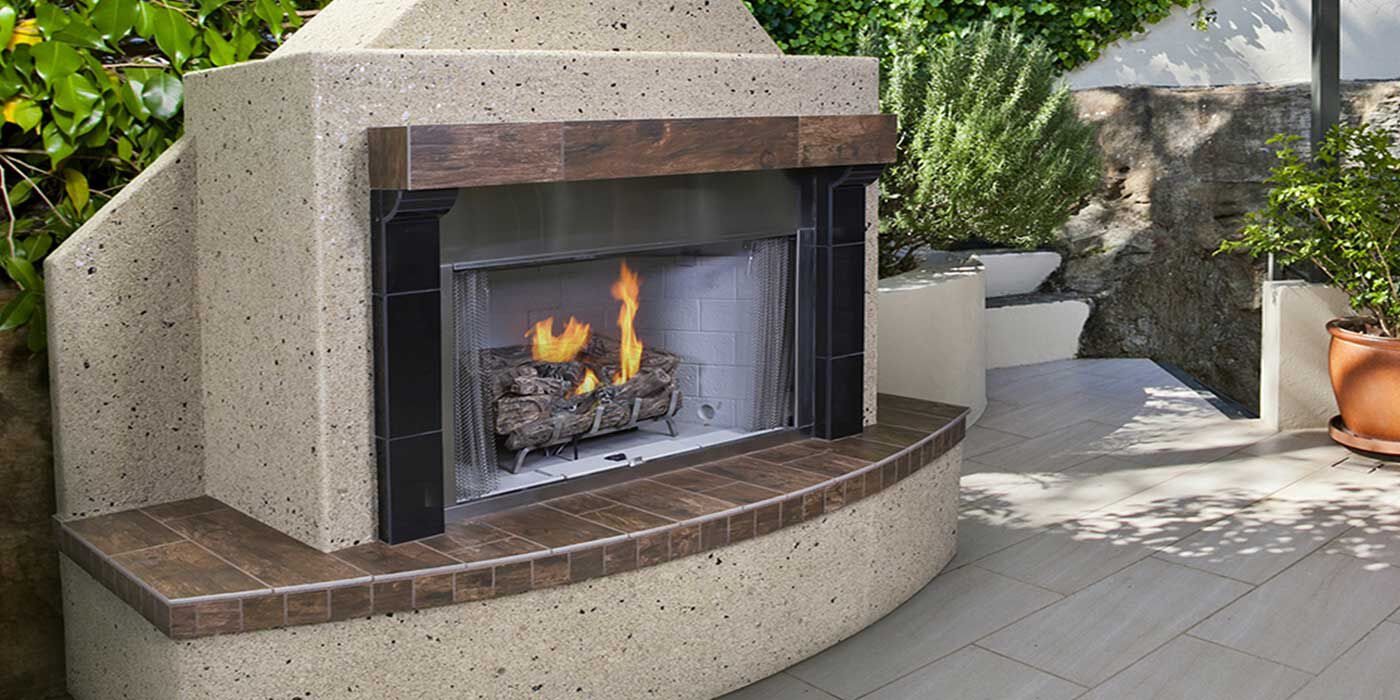 An outdoor patio space with a traditional, standalone gas fireplace.