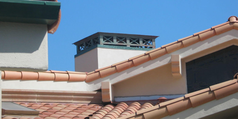 A large copper chimney shroud with a blue/green patina