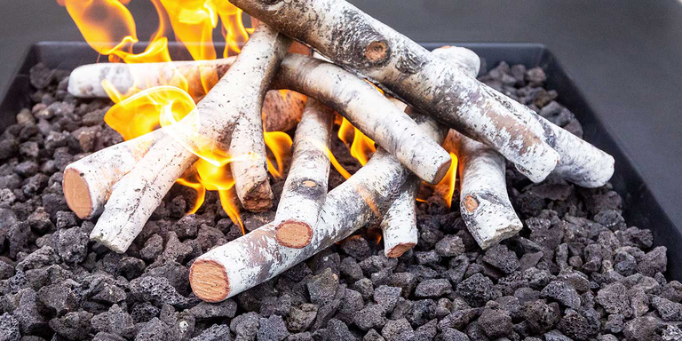 A gas fire pit with a stack of Birch-style outdoor gas logs