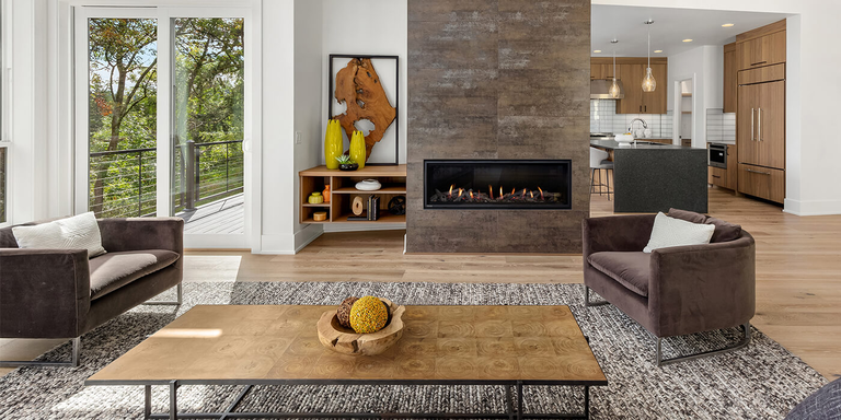 A modern indoor living room with a large hearth area and linear gas fireplace from Montigo