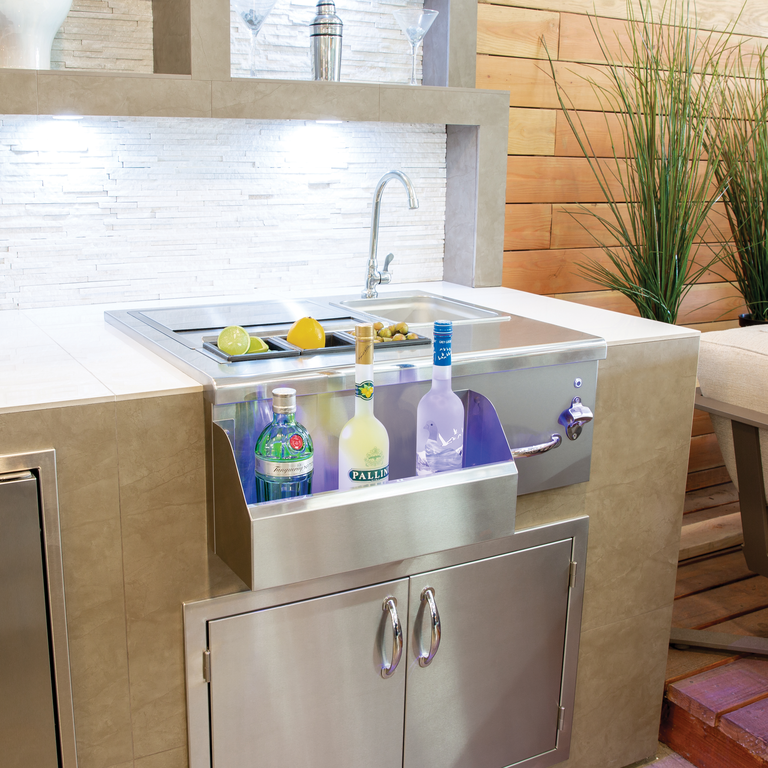 An outdoor sink and facet with storage for bar necessities, like bottles and glasses.