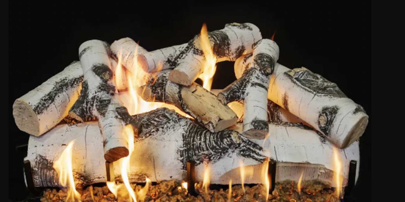 A stack of Vented Quaking Aspen logs with white bark marked with distinctive black scars.