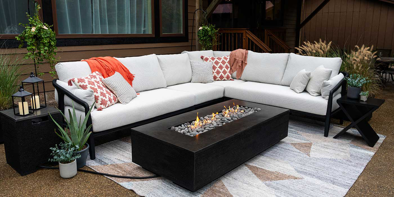 The FlameCraft Zen Gas Fire Pit and a large, white outdoor sectional in a modern patio space 