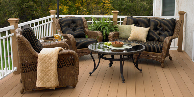 A traditional outdoor deck with three matching chairs made of resin wicker. 