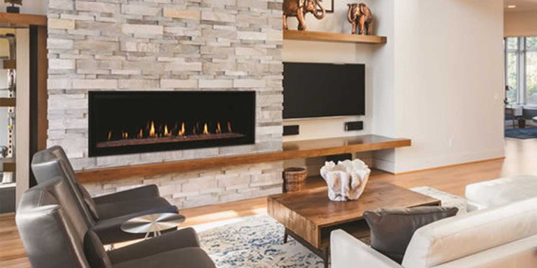 A contemporary living room with a large natural stone hearth and a linear Direct Vent gas fireplace