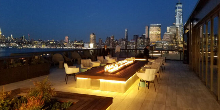 Linear fire pit on a river-front patio overlooking the city