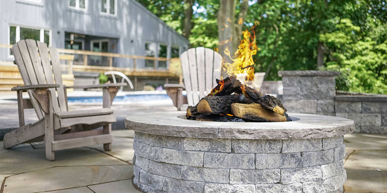 An outdoor gas fire pit with a set of ceramic gas logs