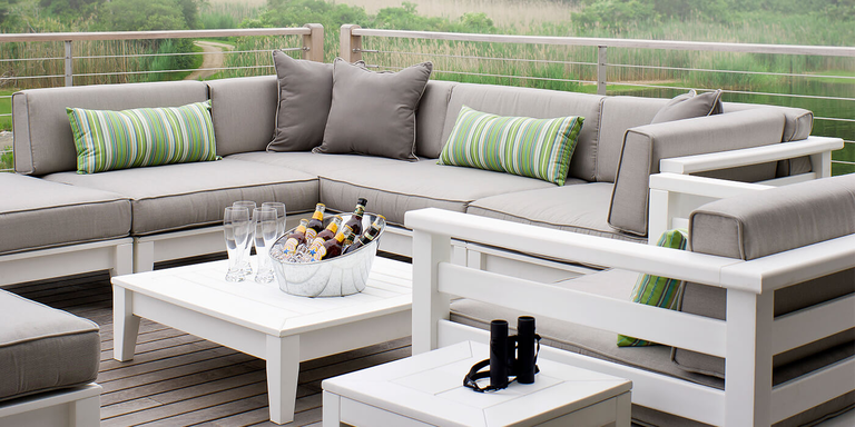 A modern outdoor furniture set with white frames and light gray cushions.