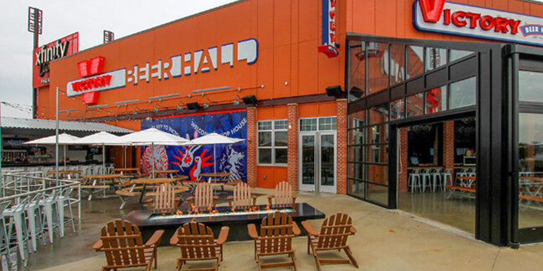 Adirondack chairs around a black fire table on the patio of the Victory Beer Hall
