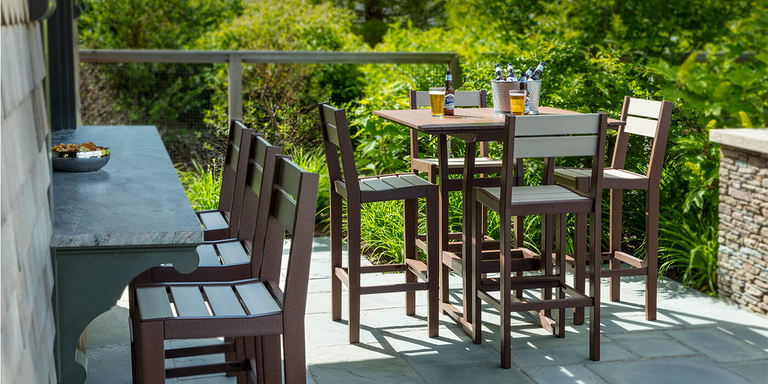 An outdoor patio space with a dining-height table and chairs.