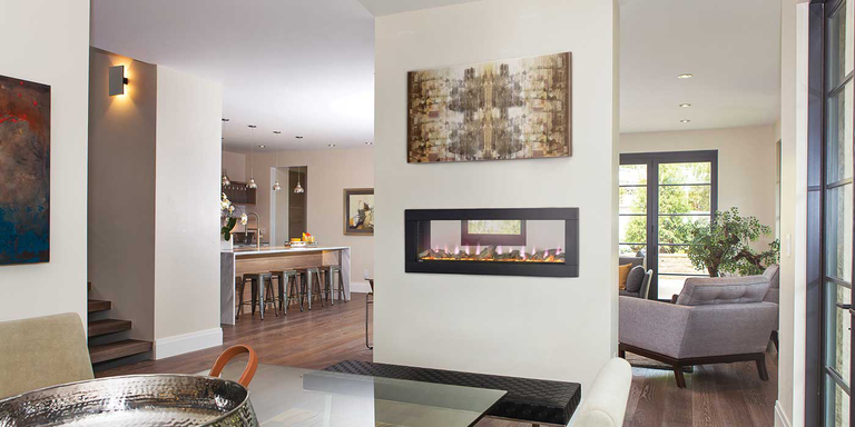 A see-through electric fireplace installed as a partition between a living room and dining area