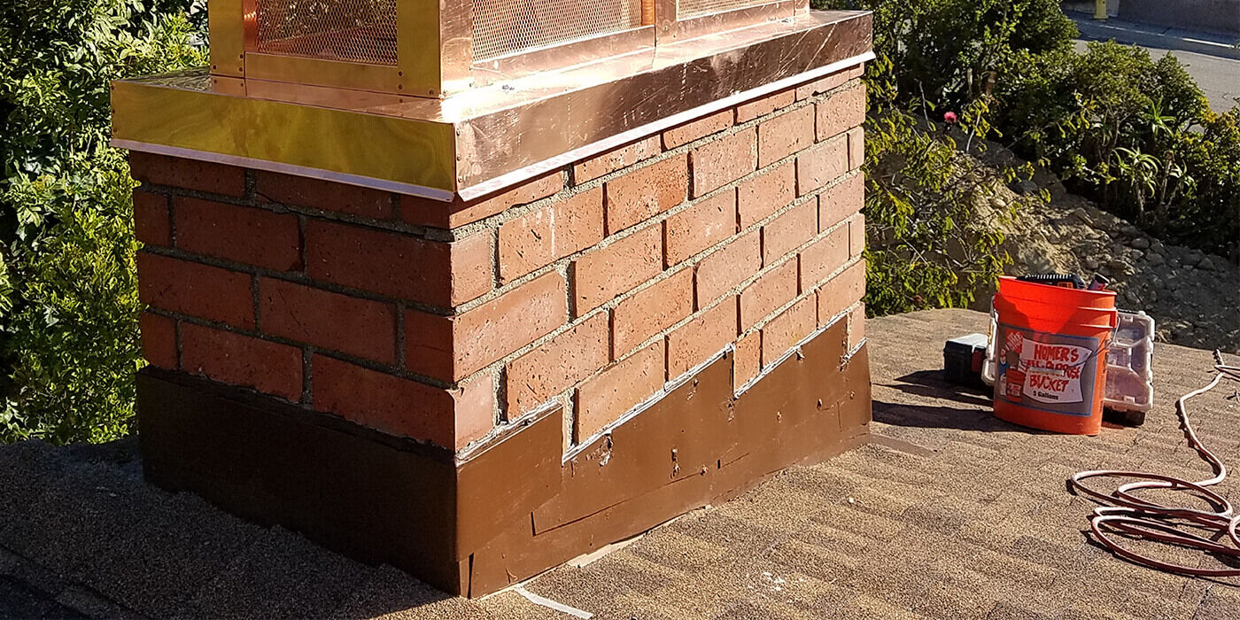picture of a masonry chimney, a copper chimney cap, step flashing, and a roof, along with some chimney maintenance products