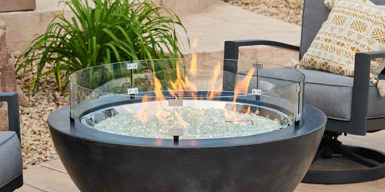 A gas fire bowl with a glass wind guard 