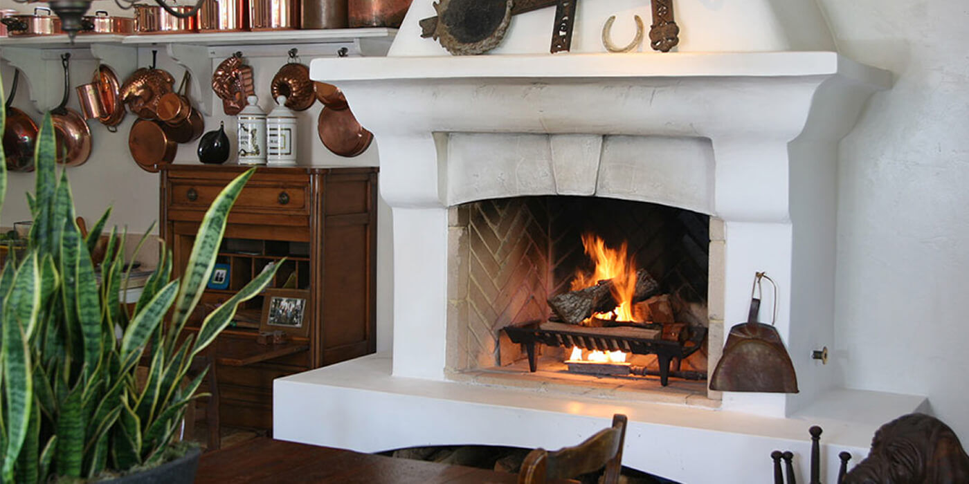 this is a photo of a traditional masonry fireplace hearth with a chimney, a log set, and chimney components