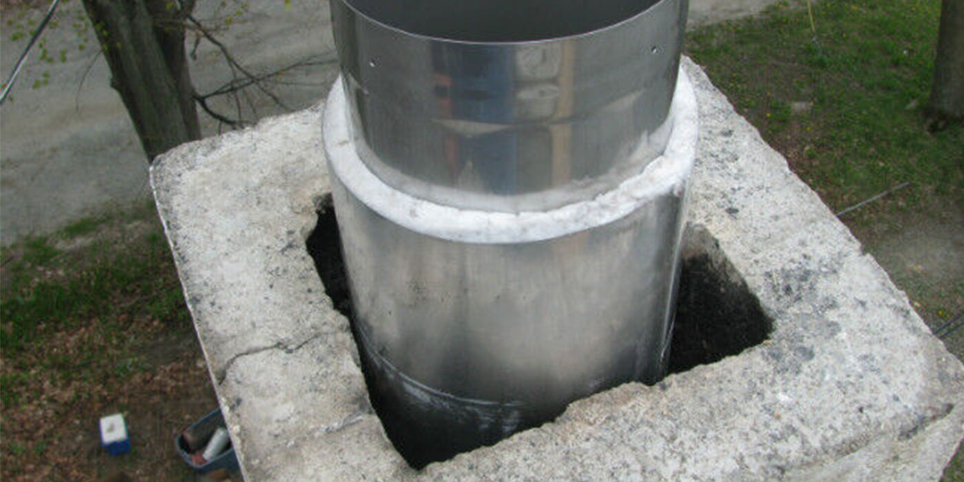 Stainless steel chimney liner sticking out of a masonry chimney