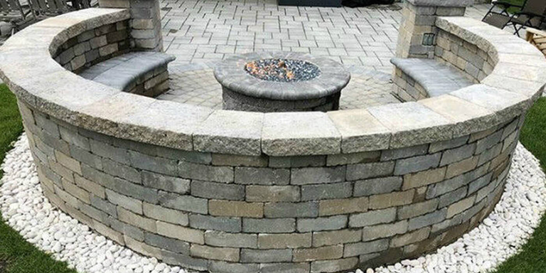 Backview of a masonry fire pit on a stone patio