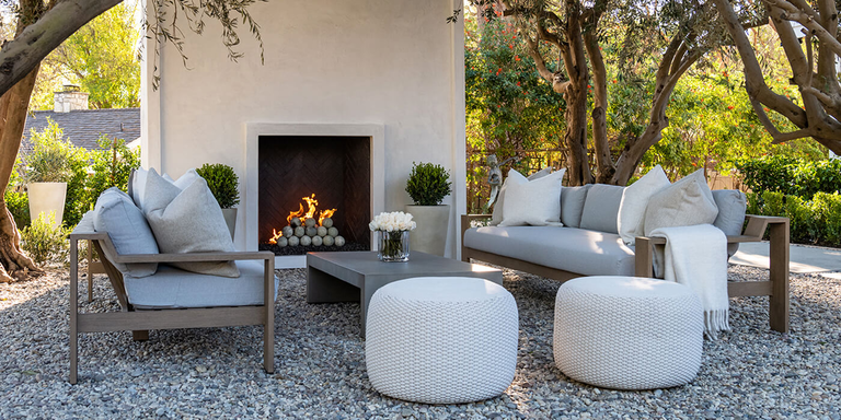 A contemporary outdoor sitting area with a modern gas fireplace that has ceramic cannon balls.