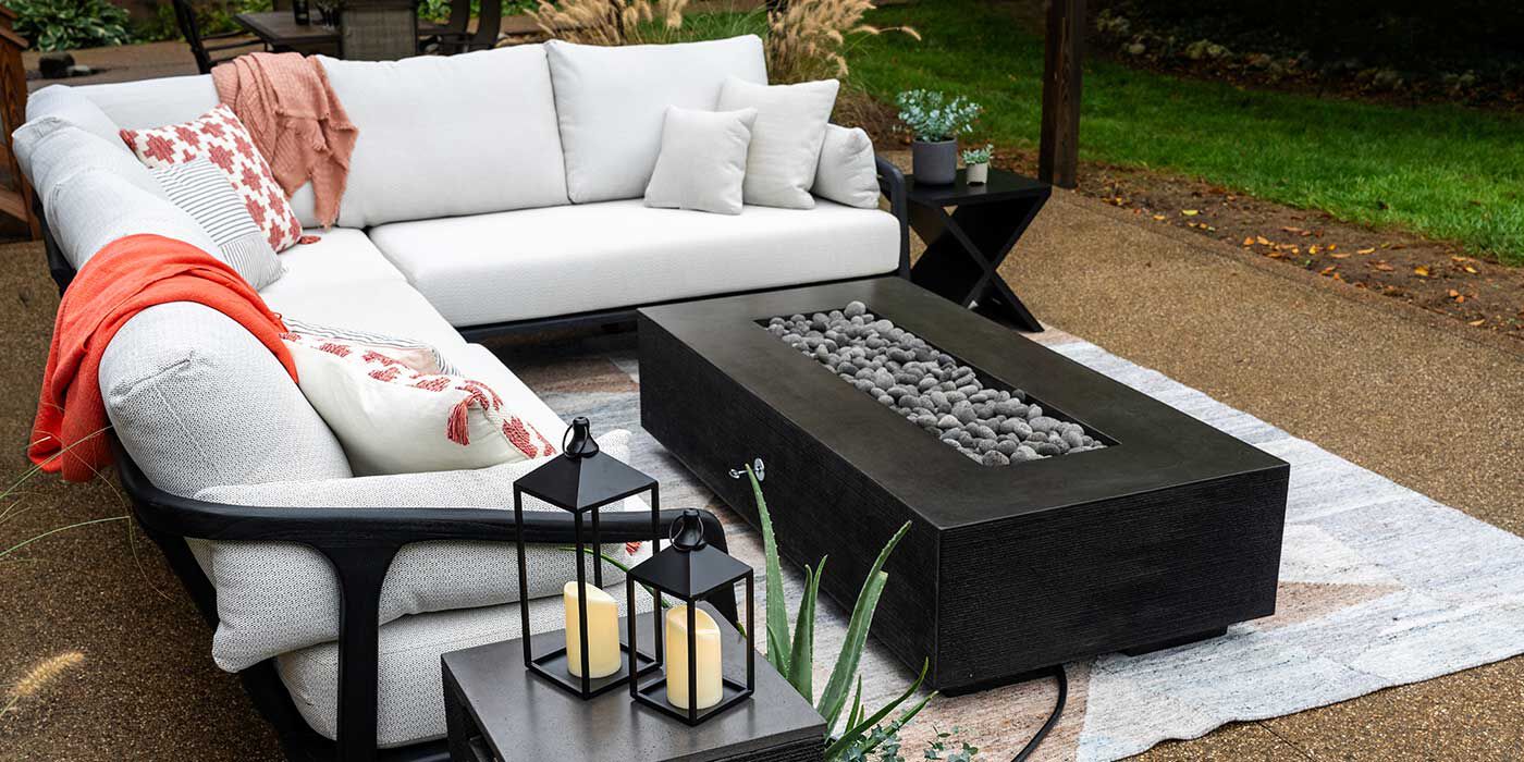 An outdoor patio space with a black FlameCraft Zen Gas Fire Pit 