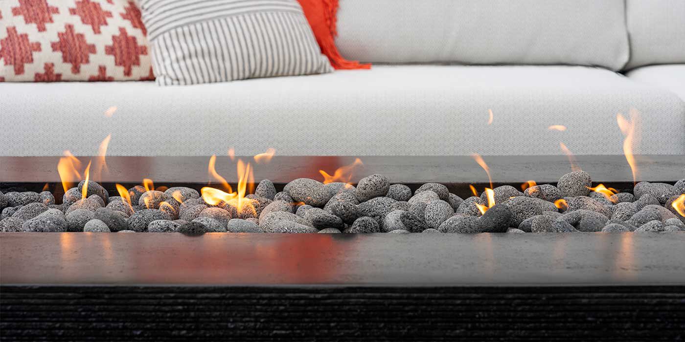 The Zen Gas Fire Pit by FlameCraft in the color Onyx, with rolled lava stone media
