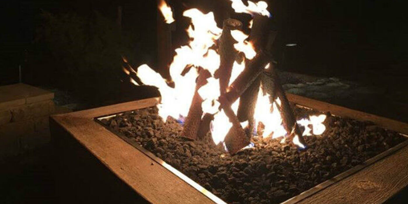Close-up of gas logs burning on a gas fire pit at nighttime
