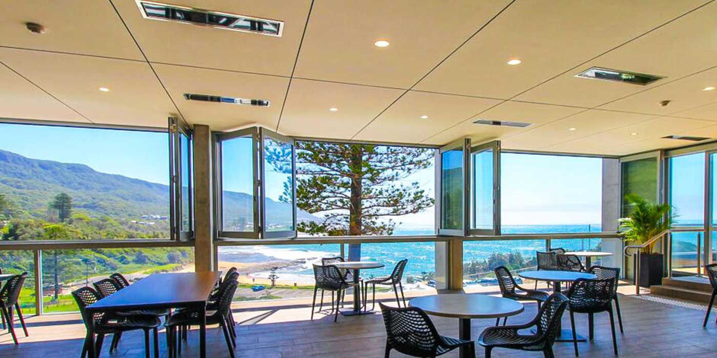 An enclosed restaurant patio space with several patio heaters recessed into the ceiling for a clean, modern look.