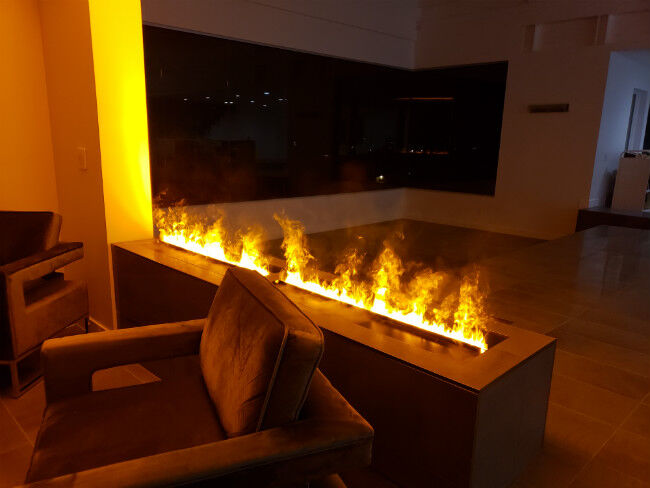A chair in front of an OptiMyst fireplace in a dark living room