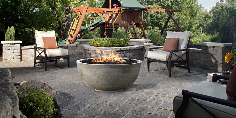 An outdoor patio space with a concrete gas fire bowl
