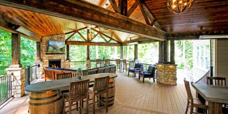 Rustic covered deck with reclaimed wood details and a gas fireplace