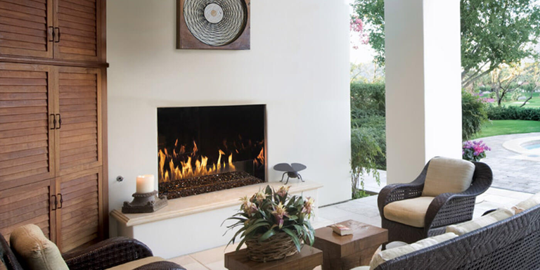 An outdoor living room with a built-in gas fireplace