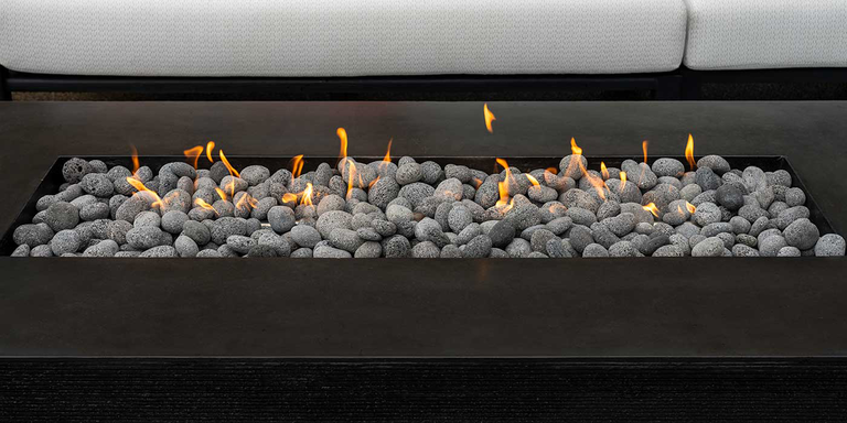 A close-up view of the Zen Gas Fire Pit by FlameCraft with a bed of rolled lava stones