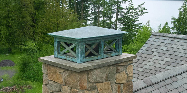 A copper chimney shroud with a blue/green patina 