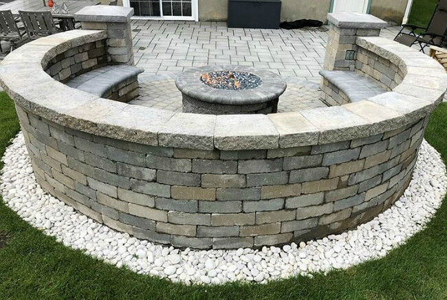 Backview of a masonry fire pit on a stone patio