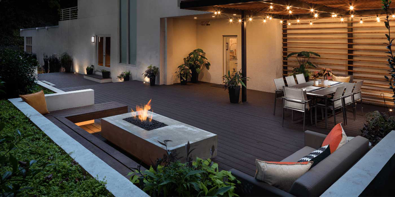An outdoor living space with a dining area, seating area, and outdoor gas fire pit hooked up to a Natural Gas line.