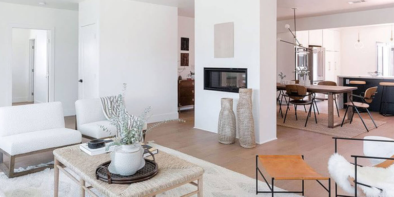 A Scandinavian-minimalist inspired home with a see-through linear gas fireplace separating the living room and dining area