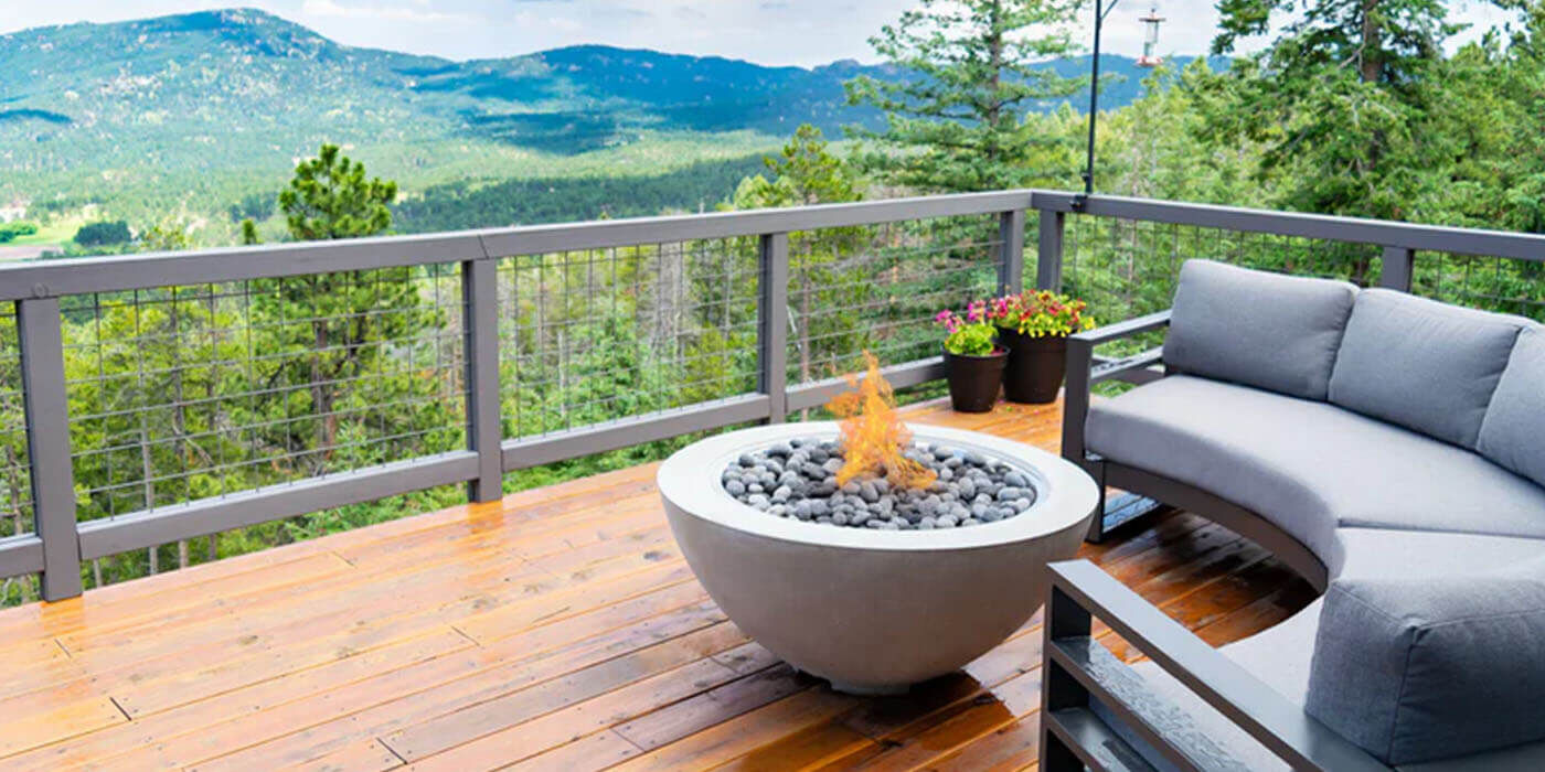 An outdoor deck with patio furniture and a compact gas fire bowl