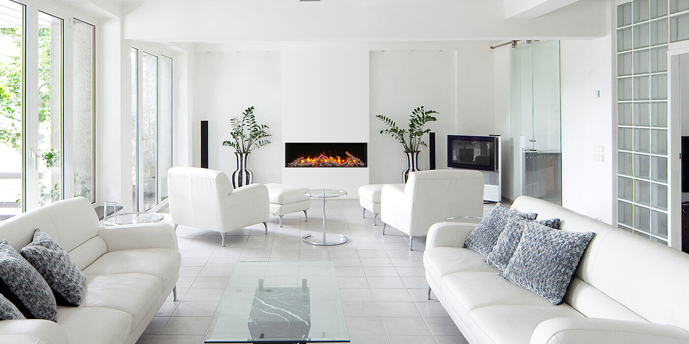 A minimalist living space with all white furniture and walls and a medium sized linear electric fireplace