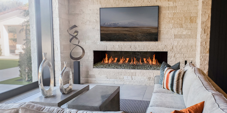 A modern living room with a linear Isokern gas fireplace with custom natural stone finishing material installed down to the fireplace opening