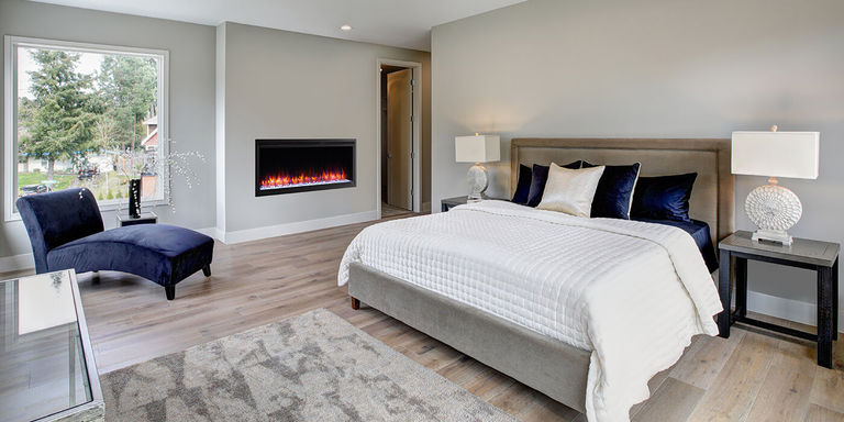 A linear electric fireplace installed in a large bedroom 