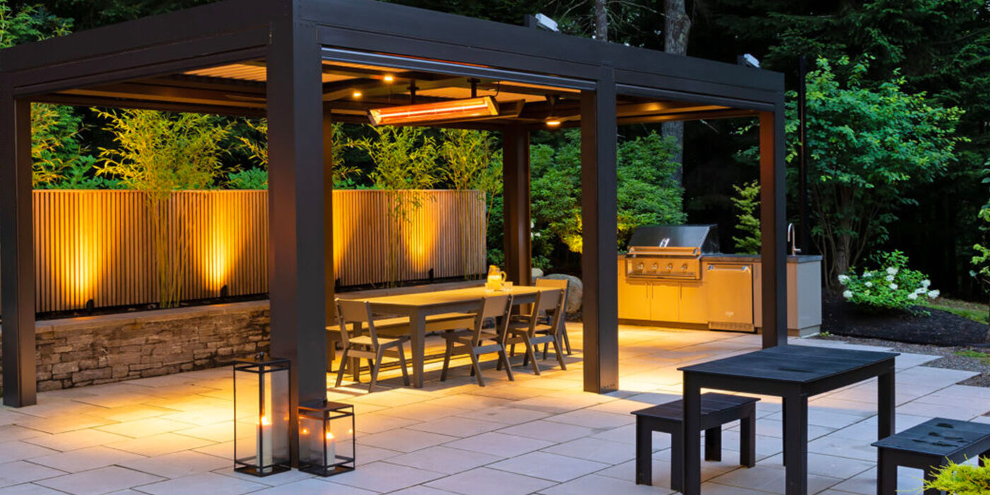 A modern outdoor dining space with custom lighting and a ceiling mounted patio heater