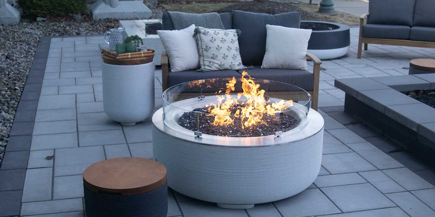 The ReForm Stack Gas Fire Pit in the color Glacier with a matching side table Propane tank enclosure